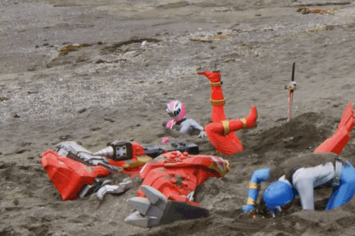 戦隊ヒーロー、リュウソウジャーのリュウソウレッドがやらて砂に埋まる。