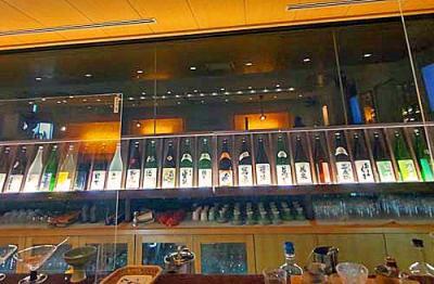 日本酒Ber香林のカウンター席から日本酒の陳列棚を見て