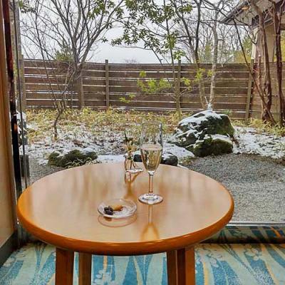 おとぎの宿米屋チェックイン時のスパークリングワインと小菓子に薄っすら雪景色の庭